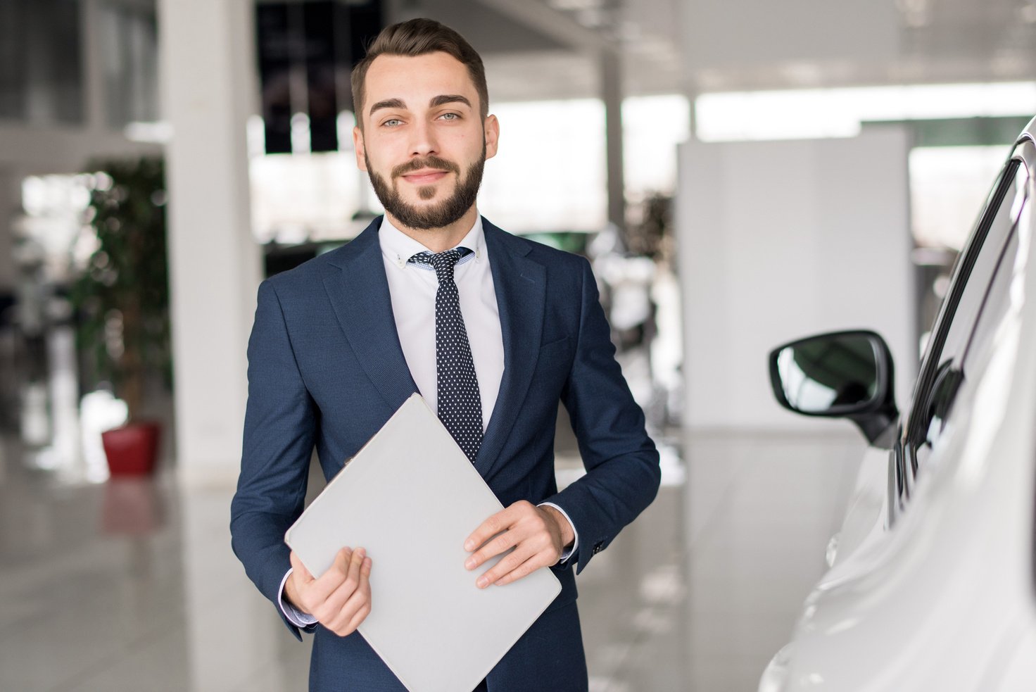 Smiling Car Salesman in Showroom