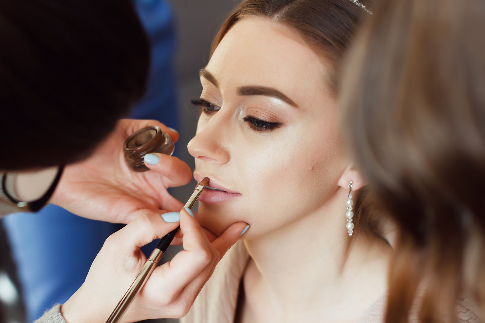 Makeup artist makes makeup to the bride.